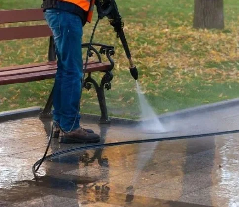 Image of a man softwashing pavers